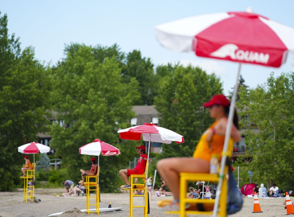 Lifeguards work at Brittany Beach of the Ottawa River in Ottawa, Friday, June 24, 2022. Ontario is proposing to lower the minimum age for lifeguards to 15, in part to address staff shortages many municipalities experienced last summer. THE CANADIAN PRESS/Sean Kilpatrick