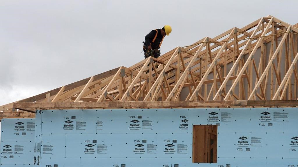 A construction worker works on a house in a new housing development