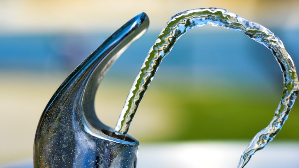 silver faucet with water droplets