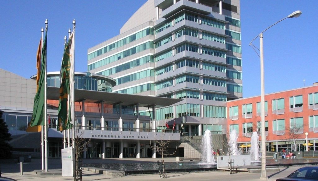 An image of Kitchener city hall, taken from the perspective of Carl Zehr Square on a sunny day.