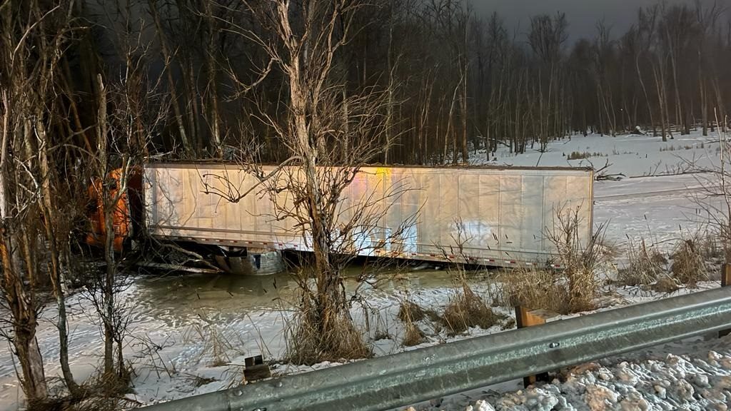 Tractortrailer jumps snowbank, crashes in frozen swamp by Highway 401