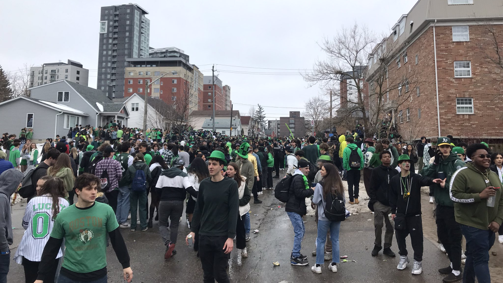 Students filling a street dressed in green.