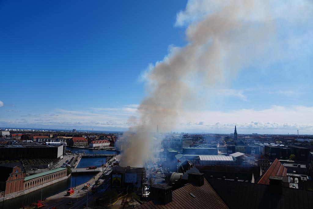 Fire rages through the 17th-century Old Stock Exchange in Copenhagen, toppling the iconic spire