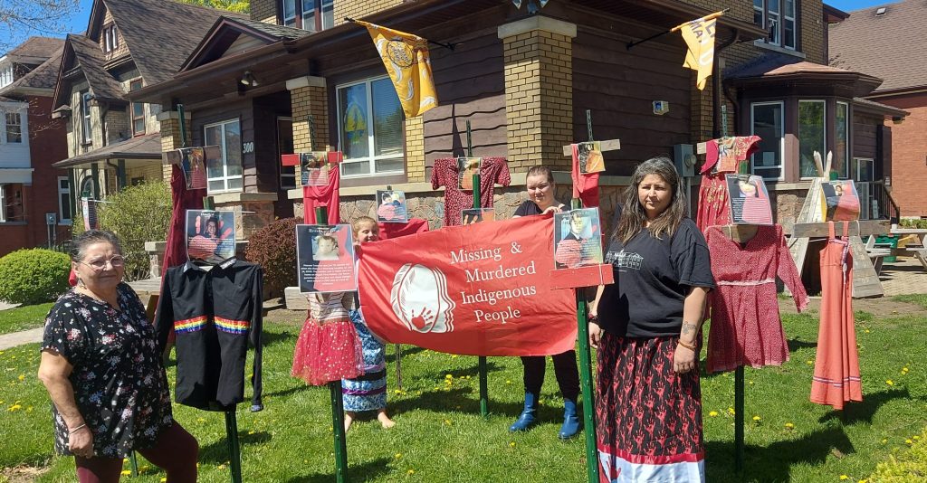 Donna Dubie (left), Serena Wesley (right) and members of The Healing of The Seven Generations stand next to display. May 2, 2024. (Justine Fraser, CityNews 570.)