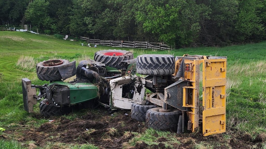 Farm tractor on its side on grass