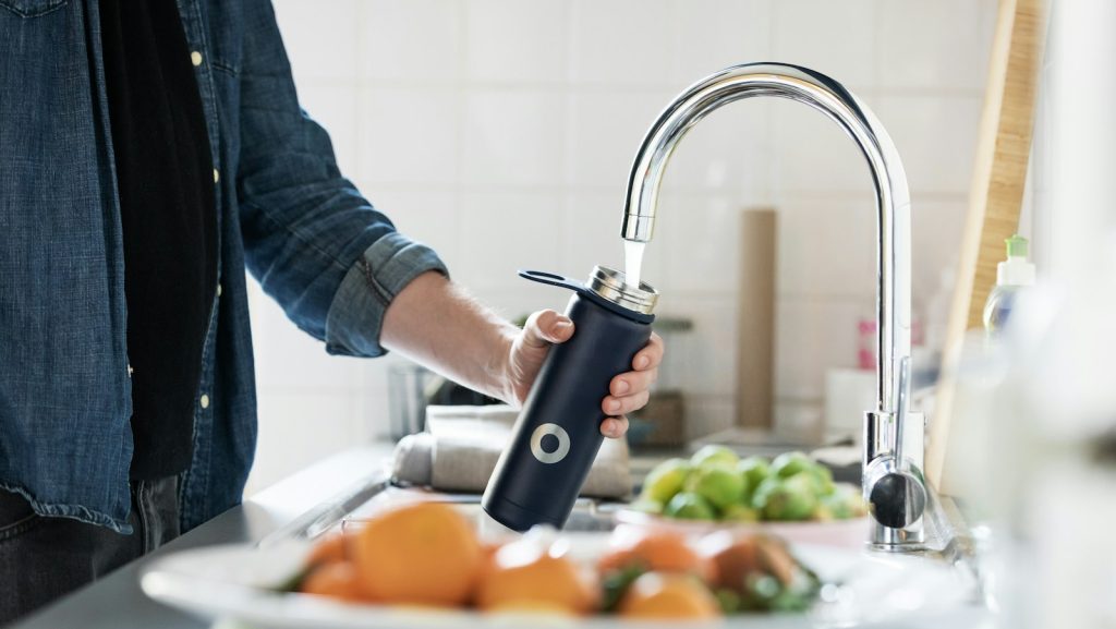 person holding stainless steel faucet