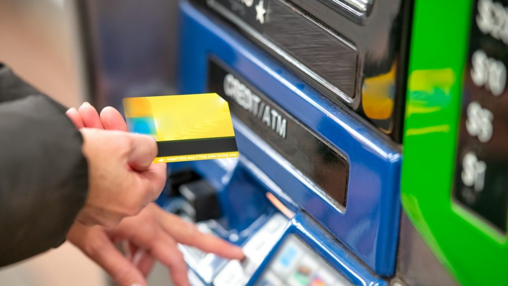 a person using a credit card to pay for a machine