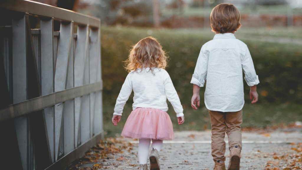 boy beside girl walking near railing