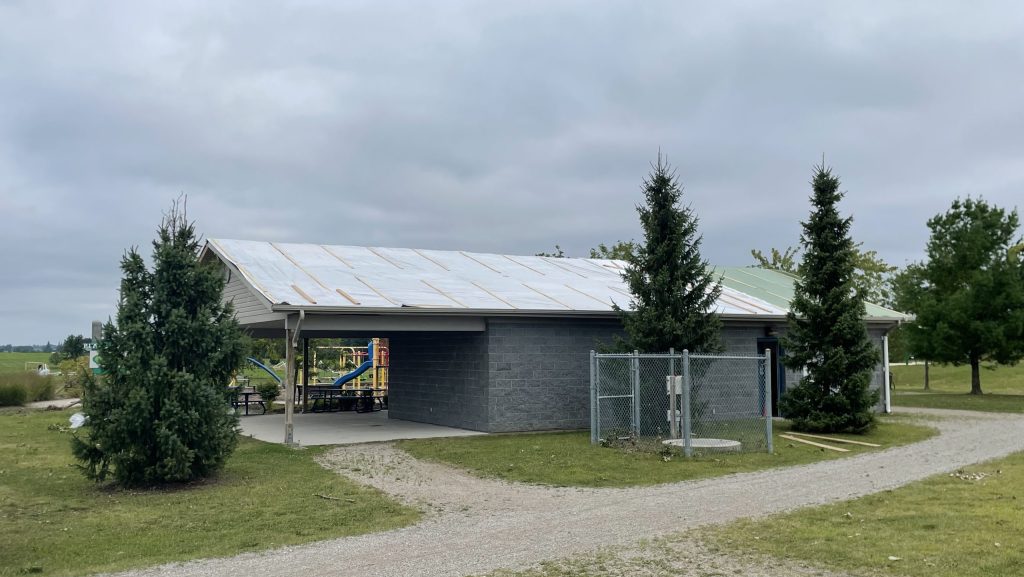 The roof of the concession stand at Cowan Park in Ayr, covered in plywood and tarps.