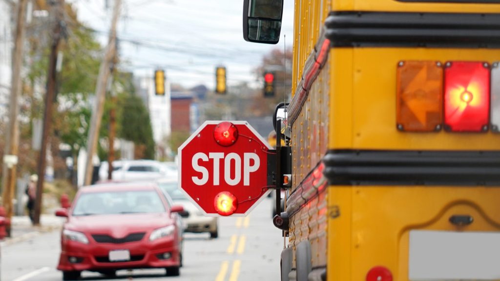 A car stops for a school bus with its lights flashing. (CityNews file)