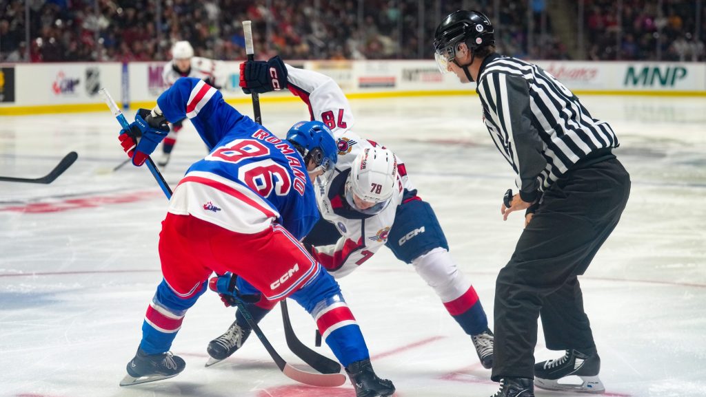 Luca Romano taking a faceoff against Spitfires forward Cole Davis. (photo from Remo Agostino/ Windsor Spitfires)