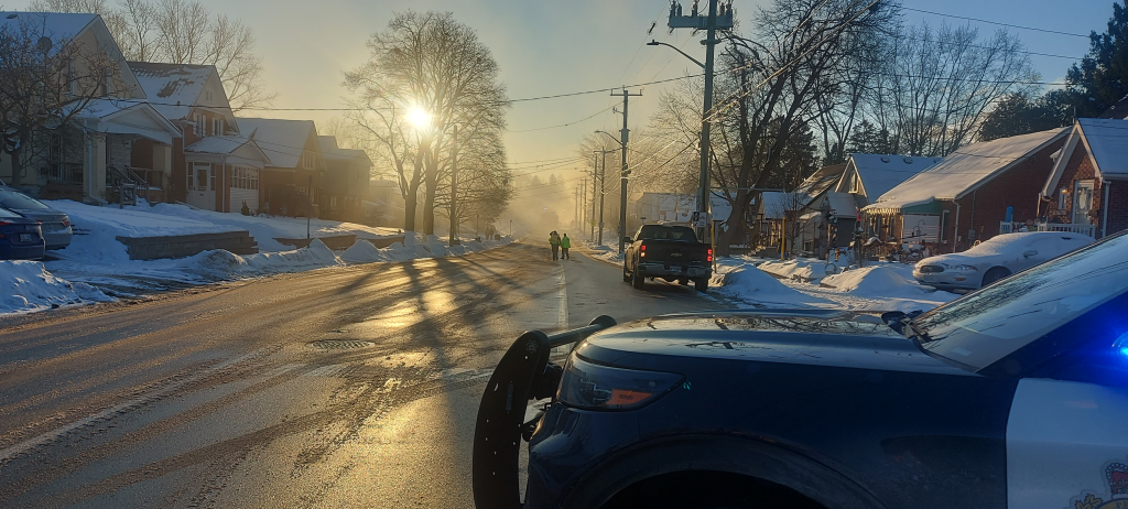 police vehicles on a snowy street with smoke in the background