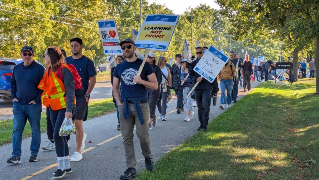 Picketers march outside of Conestoga College's Doon Campus.