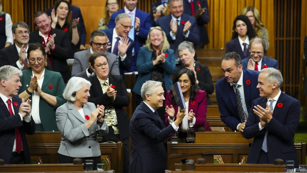 Finance Minister Francois-Philippe Champagne holds up a copy of the budget after delivering his speech in the House of Commons, in Ottawa, Tuesday, Nov. 4, 2025. THE CANADIAN PRESS/Sean Kilpatrick